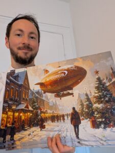 Lasse Frank holder Teatret Zeppelins låge-julekalender frem. Julekalenderen har 24 låger og motiver i hyggelig, nostalgisk, og let gammeldags maleristil.